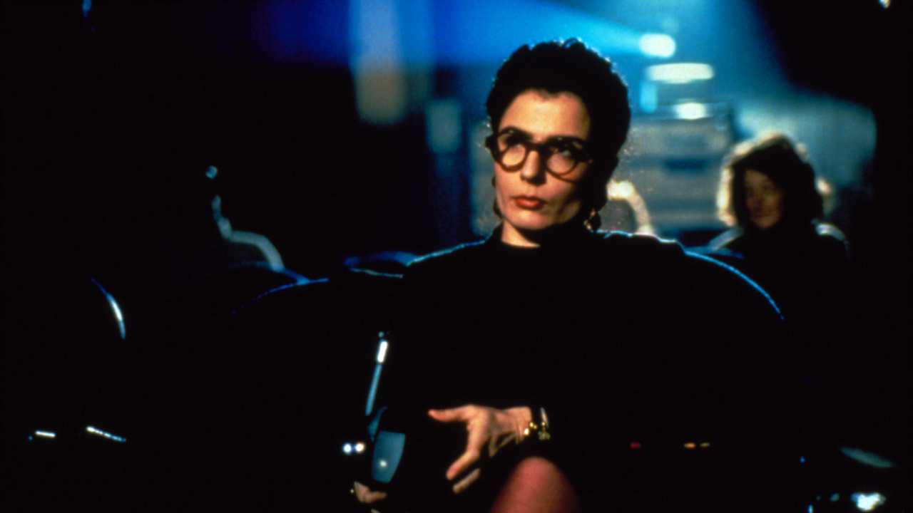 a woman with glasses sitting watching a film